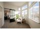 This bright bedroom features a cozy chair, end table, and natural light at 8401 Airmont Ct, Las Vegas, NV 89128