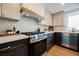 A bright kitchen with stainless appliances, white upper cabinets, dark base cabinets, and stone countertops at 8401 Airmont Ct, Las Vegas, NV 89128