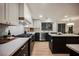 A modern kitchen with stainless appliances, white upper cabinets, dark base cabinets, and stone countertops at 8401 Airmont Ct, Las Vegas, NV 89128