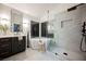 A luxurious bathroom featuring a soaking tub, glass-enclosed shower, dark vanity, and stylish fixtures at 8401 Airmont Ct, Las Vegas, NV 89128