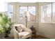 Inviting sitting area with large windows, cozy chair, and stylish decor create a relaxing space at 8401 Airmont Ct, Las Vegas, NV 89128