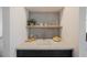 A stylish wet bar with sleek gray backsplash, floating wood shelf, and black cabinetry at 8401 Airmont Ct, Las Vegas, NV 89128