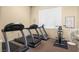 Bright exercise room featuring treadmills, stationary bike, and a fitness chart for varied workouts at 8501 W University Ave # 1002, Las Vegas, NV 89147