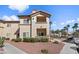 Two-story condo featuring desert landscaping, a staircase, and a private balcony at 8501 W University Ave # 1002, Las Vegas, NV 89147