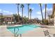 Community pool with ample seating, tall palm trees, and well-maintained grounds at 8501 W University Ave # 1002, Las Vegas, NV 89147