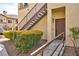 Exterior view of home's front door and access stairs, accented by lush landscaping at 8501 W University Ave # 1042, Las Vegas, NV 89147