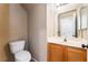 Half bathroom featuring wood cabinet sink and toilet at 9360 Canalino Dr, Las Vegas, NV 89134