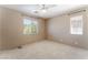 A simple bedroom features neutral walls, white carpet and two windows at 9360 Canalino Dr, Las Vegas, NV 89134