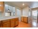 Bright kitchen featuring wood cabinets, tile counters, hardwood flooring and an open pass-through to the living area at 9360 Canalino Dr, Las Vegas, NV 89134