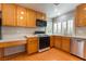 Bright kitchen equipped with wood cabinets, laminate floors, and stainless steel appliances at 9360 Canalino Dr, Las Vegas, NV 89134