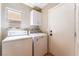 A laundry room with a washer and dryer, storage cabinets and a side access door at 9360 Canalino Dr, Las Vegas, NV 89134