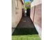 Narrow side yard featuring decorative rock and green grass leading to the rear gate at 9360 Canalino Dr, Las Vegas, NV 89134