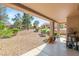Expansive backyard featuring desert landscaping, a covered patio, and mature trees offering shade at 9445 January Dr, Las Vegas, NV 89134