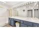 Bathroom vanity with double sinks, large mirrors with Hollywood lights and walk-in shower at 9445 January Dr, Las Vegas, NV 89134