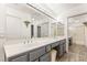Bathroom vanity with double sinks, large mirrors with Hollywood lights and walk-in shower at 9445 January Dr, Las Vegas, NV 89134