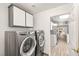 Laundry room with front-loading washer and dryer, cabinets and doorway to kitchen at 9445 January Dr, Las Vegas, NV 89134