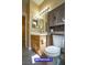 Bathroom with wood cabinets, white counter and toilet with built-in storage shelf at 9710 Geiger Peak Ct, Las Vegas, NV 89148