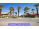 Street view of the community entrance with palm trees, landscaping, and the community name sign at 9710 Geiger Peak Ct, Las Vegas, NV 89148