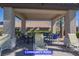 Covered seating area at community pool with tables and lounge chairs at 9710 Geiger Peak Ct, Las Vegas, NV 89148