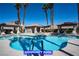Community pool with palm trees, lounge chairs, and covered seating area at 9710 Geiger Peak Ct, Las Vegas, NV 89148