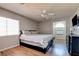 Comfortable bedroom with a ceiling fan, wood flooring, and a mounted television at 982 Flapjack Dr, Henderson, NV 89014