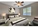 Cozy bedroom with a ceiling fan, window, and a well-made bed at 10201 Premia Pl, Las Vegas, NV 89135