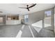 Living room flows into the kitchen and dining area with lots of natural light, carpet floors, and a modern ceiling fan at 10201 Premia Pl, Las Vegas, NV 89135