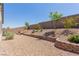Spacious backyard featuring rock landscaping, a retaining wall and greenery at 10257 Sequoia Falls Pl, Las Vegas, NV 89149