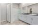 Bathroom with a double sink vanity, granite countertops, and a glass-enclosed shower at 10257 Sequoia Falls Pl, Las Vegas, NV 89149