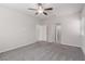 Spacious bedroom with a ceiling fan and plush carpeting, featuring multiple doorways and lots of natural light at 10257 Sequoia Falls Pl, Las Vegas, NV 89149