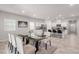 Bright dining area with modern glass table and plush rug, seamlessly connecting to a sleek, white kitchen at 10257 Sequoia Falls Pl, Las Vegas, NV 89149