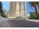 View of the high rise with an elegant entrance, circular driveway, and manicured landscaping at 125 E Harmon Ave # 321, Las Vegas, NV 89109