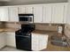 Modern kitchen features white cabinets, stainless steel microwave, and granite countertops at 1712 Matador Way, Las Vegas, NV 89128