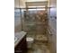 Shower with accessibility hand rails, patterned beige tilework, and sliding glass doors at 1712 Matador Way, Las Vegas, NV 89128