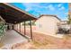 View of backyard showcasing an open patio, storage shed, and minimal landscaping under a bright blue sky at 1733 N Michael Way, Las Vegas, NV 89108