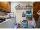 A cluttered laundry room with a washer, dryer, utility sink and overhead storage at 1733 N Michael Way, Las Vegas, NV 89108