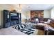 Living room featuring leather sofas, a zebra-print rug, a stone accent wall, and a hanging chandelier at 1733 N Michael Way, Las Vegas, NV 89108