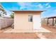 Small backyard shed with a window and white door on a gravel lot with a concrete foundation at 1733 N Michael Way, Las Vegas, NV 89108