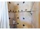 Close-up of the shower with travertine tile, mosaic accents, shower head and built-in seat at 1733 N Michael Way, Las Vegas, NV 89108