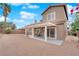 Wide view of backyard showing covered patio, sliding glass doors, rock landscaping, and mature plants at 1893 Donnington Ct, Las Vegas, NV 89123