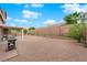 Spacious backyard with rock landscaping, patio cover, brick fence, and mature plants at 1893 Donnington Ct, Las Vegas, NV 89123