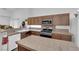 Kitchen featuring a large island, wooden cabinets, and stainless steel appliances at 1893 Donnington Ct, Las Vegas, NV 89123