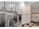 Functional laundry room with a washer and dryer, storage cabinets, and unique flooring at 2016 Catalina Marie Ave, Henderson, NV 89074