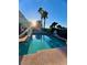 Backyard pool with lounge chairs and mature palm trees under a bright blue sky at 2016 Catalina Marie Ave, Henderson, NV 89074