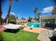 Inviting backyard with a sparkling pool, lush landscaping, and a cozy hammock at 2016 Catalina Marie Ave, Henderson, NV 89074