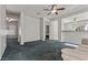 Bright living room featuring soft carpet, a ceiling fan, and a view to the kitchen at 2158 Indigo Creek Ave, Henderson, NV 89012