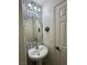 Stylish powder room featuring patterned wallpaper and a pedestal sink with an oval mirror at 2229 Steele St, Las Vegas, NV 89156