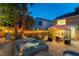 Backyard features a spa, string lights, patio seating with lush landscaping and ambient lighting for nighttime enjoyment at 2232 Le Conte Ave, Henderson, NV 89074