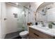 Modern bathroom featuring a glass-enclosed shower, sleek vanity, and stylish decorative wallpaper at 2232 Le Conte Ave, Henderson, NV 89074