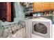 This functional laundry room includes a front loading washer and dryer, storage cabinets, and a folding rack at 2232 Le Conte Ave, Henderson, NV 89074